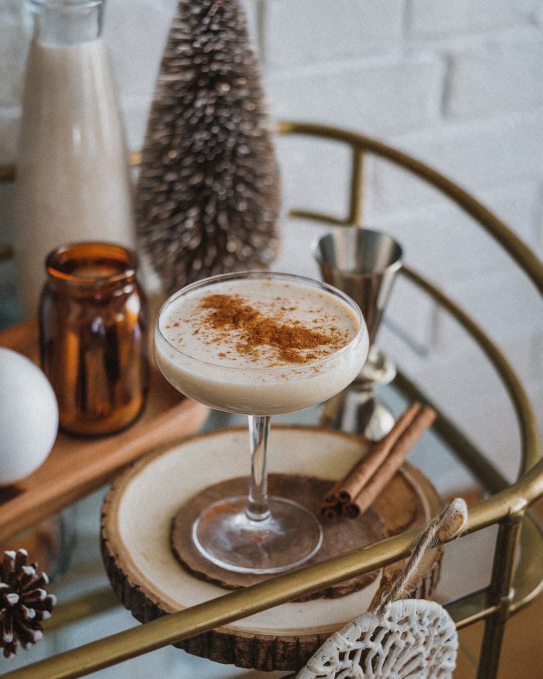 egg nog on a boho bar cart showing holiday movie themed cocktails to make at home