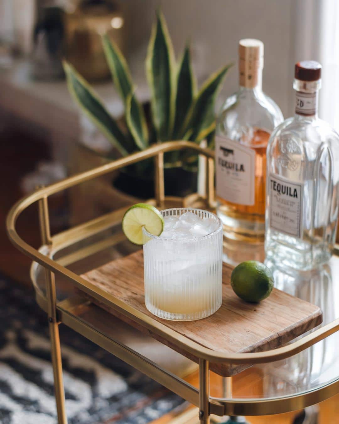 A refreshing margarita on the rocks with a bottle of premium tequila in the background, perfect for making the best tequila brands for margaritas and tequila cocktails.