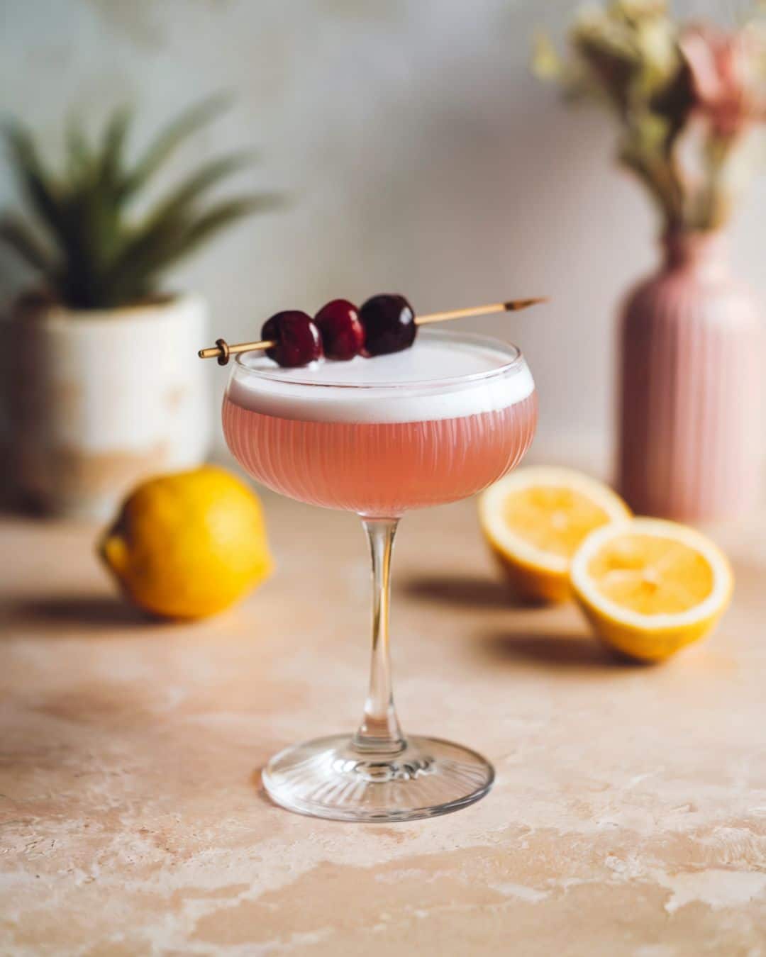 pink lady gin cocktail made with gin, lemon, grenadine and garnished with a cherry